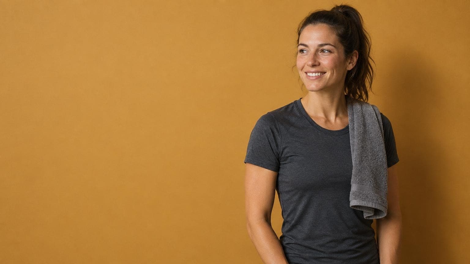 A gym owner with a towel over her shoulder and her class sign-ups running on their own